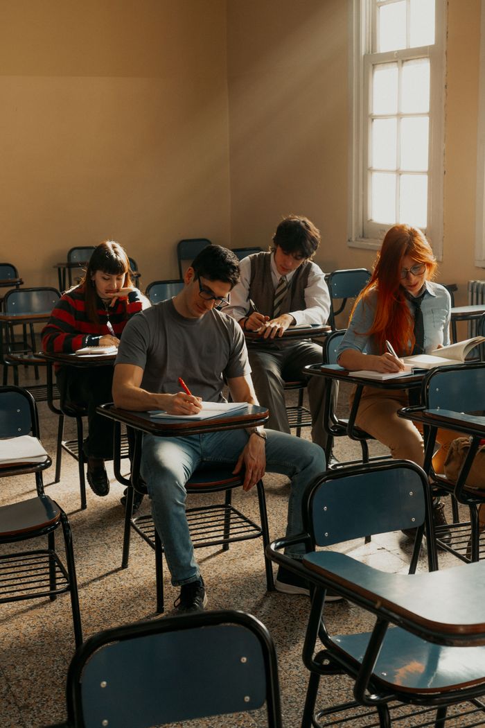 Mastering the First Impression: Your intriguing post title goes here A group of university students concentrating during an exam in a sunlit classroom.